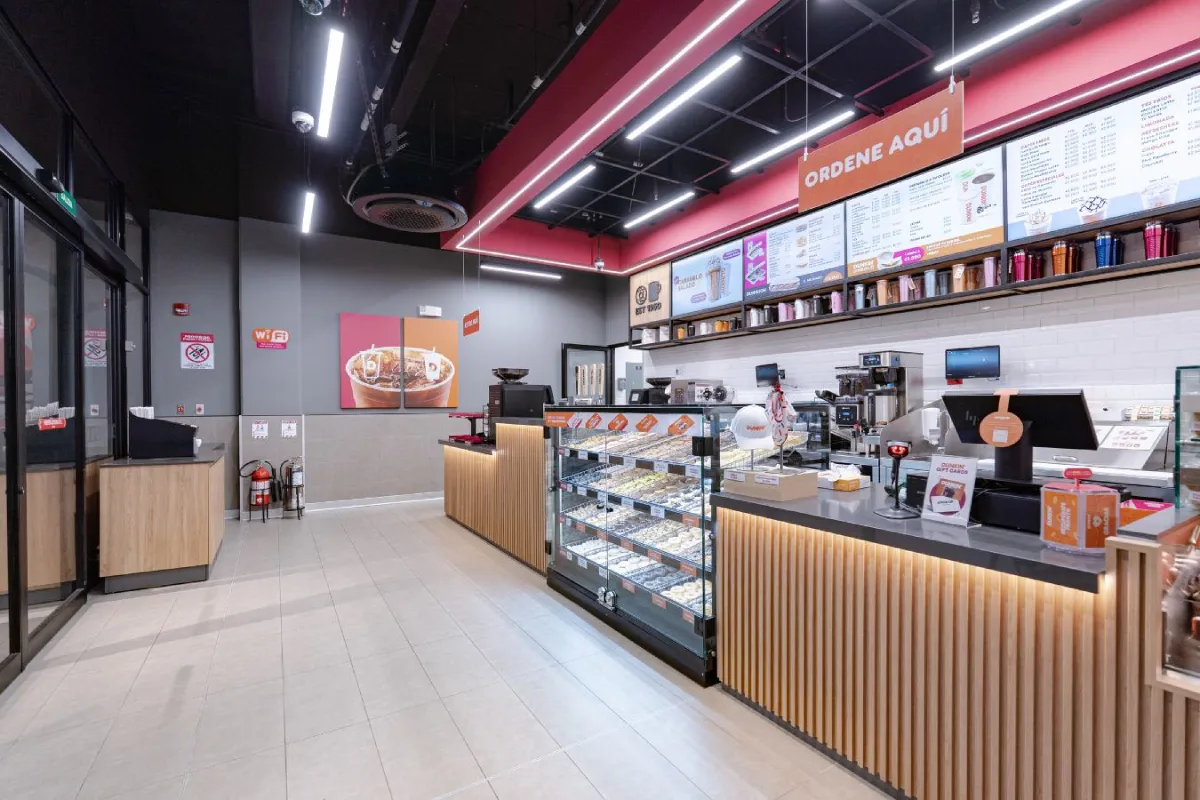 Dunkin Donuts - Service counter design featuring wood paneling and digital menu boards - Contract Workplaces.webp